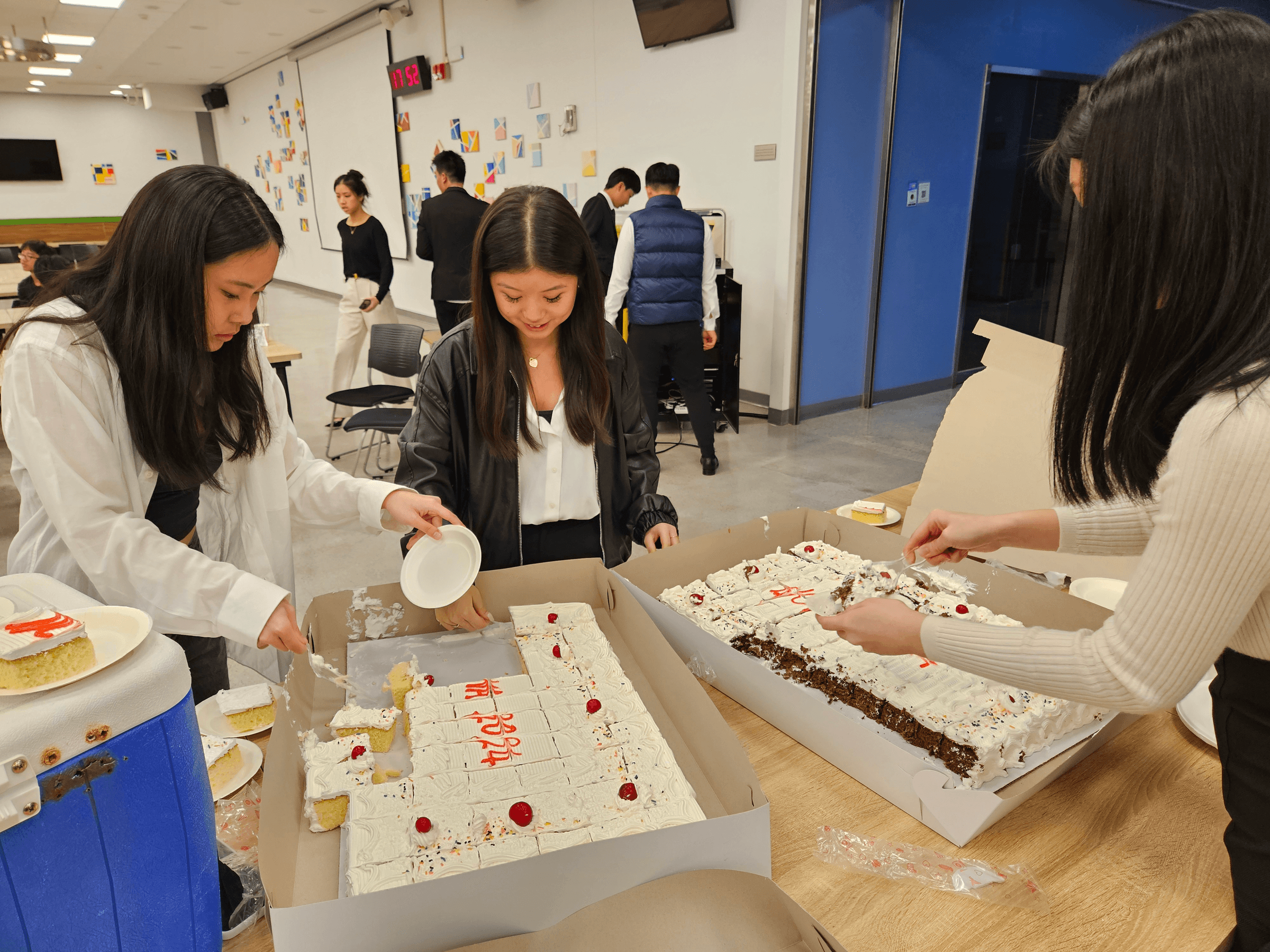 Students cut up portions of a cake
